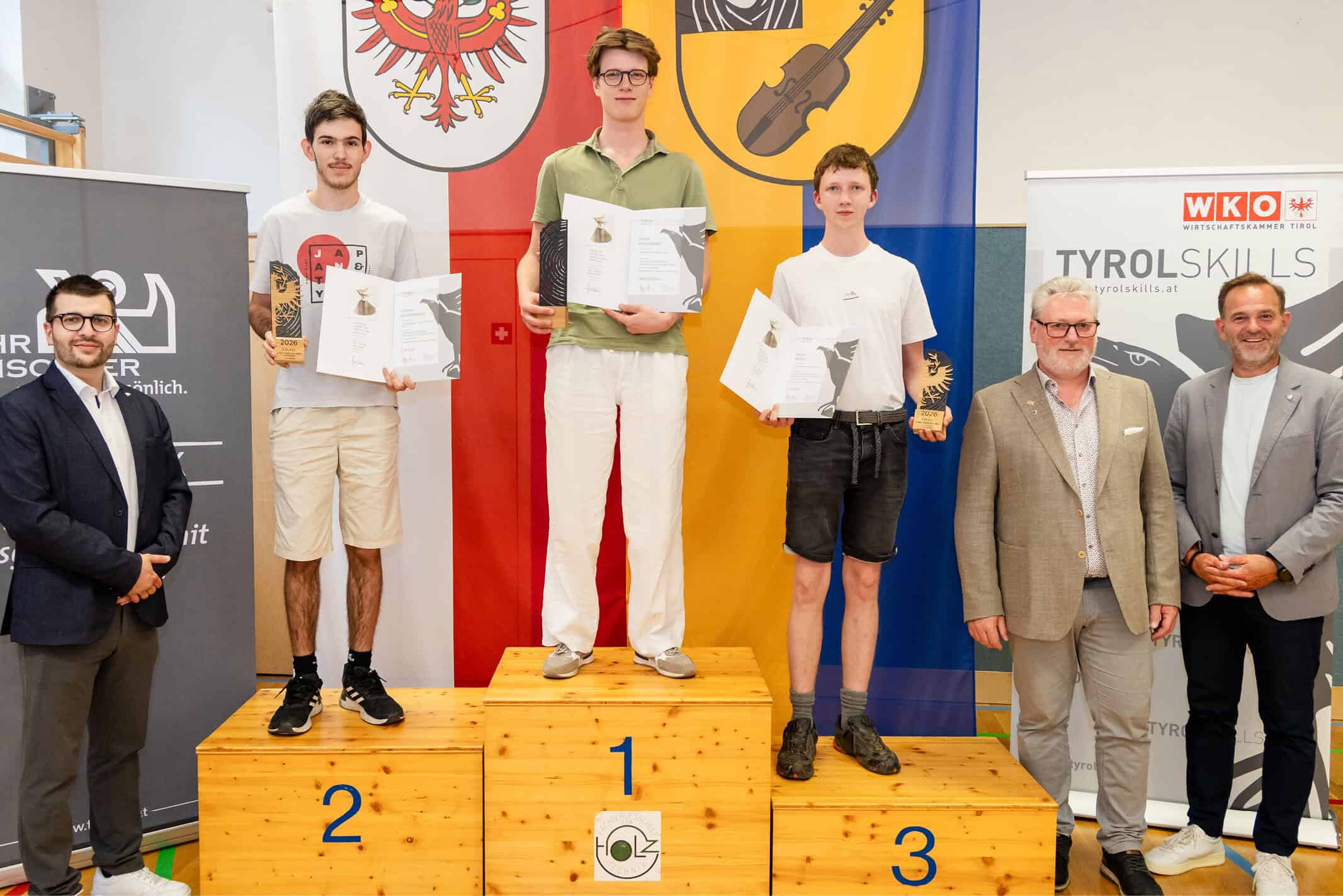 Team von Tischlern präsentiert Holzwerkstück in Werkstatt, Fokus auf Handwerkskunst und Qualität.