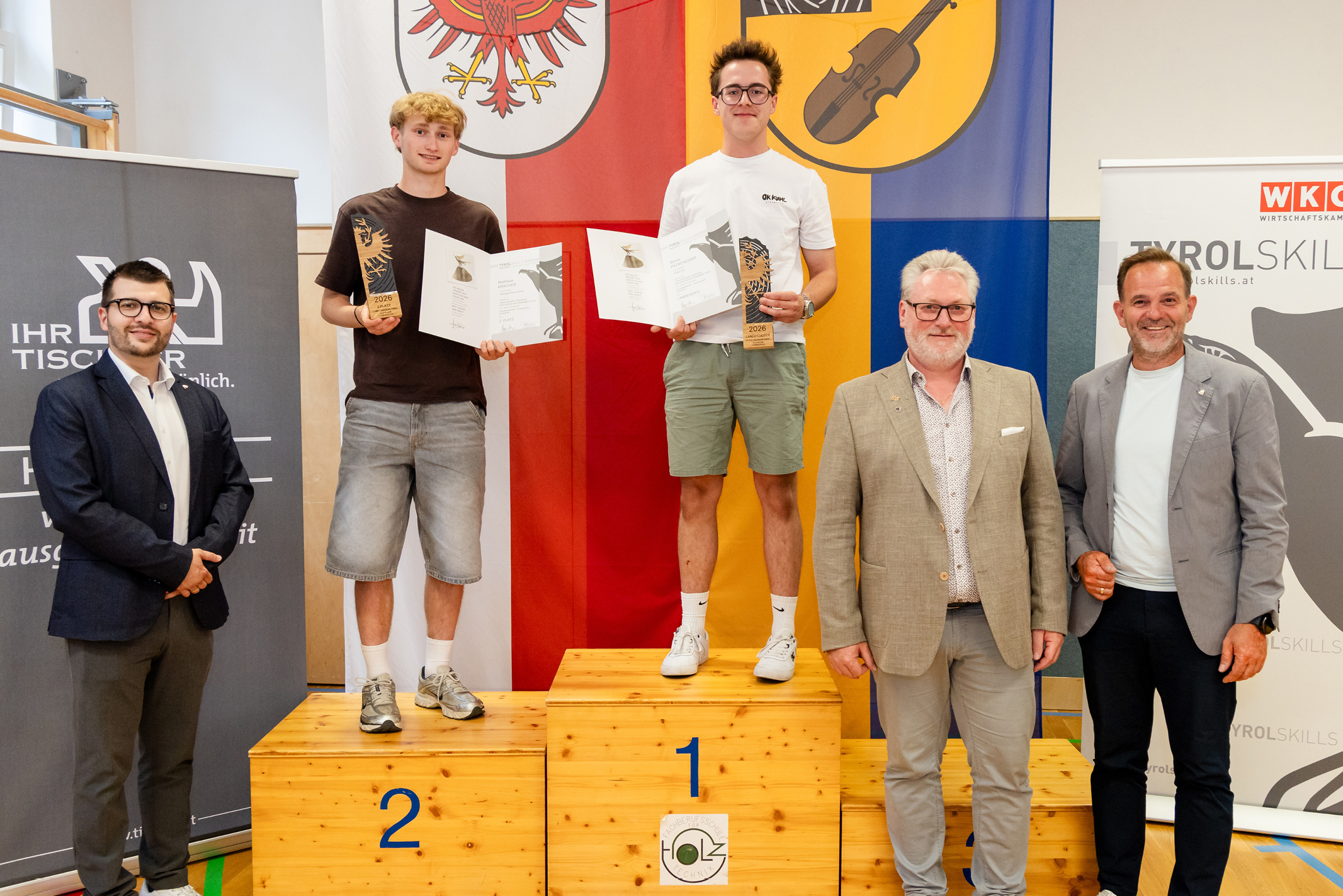 Gewinner des Tischlerwettbewerbs auf dem Siegerpodest bei der WKO Veranstaltung.