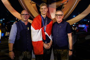 Tischler bei WorldSkills 2026 mit Medaille und Flagge.